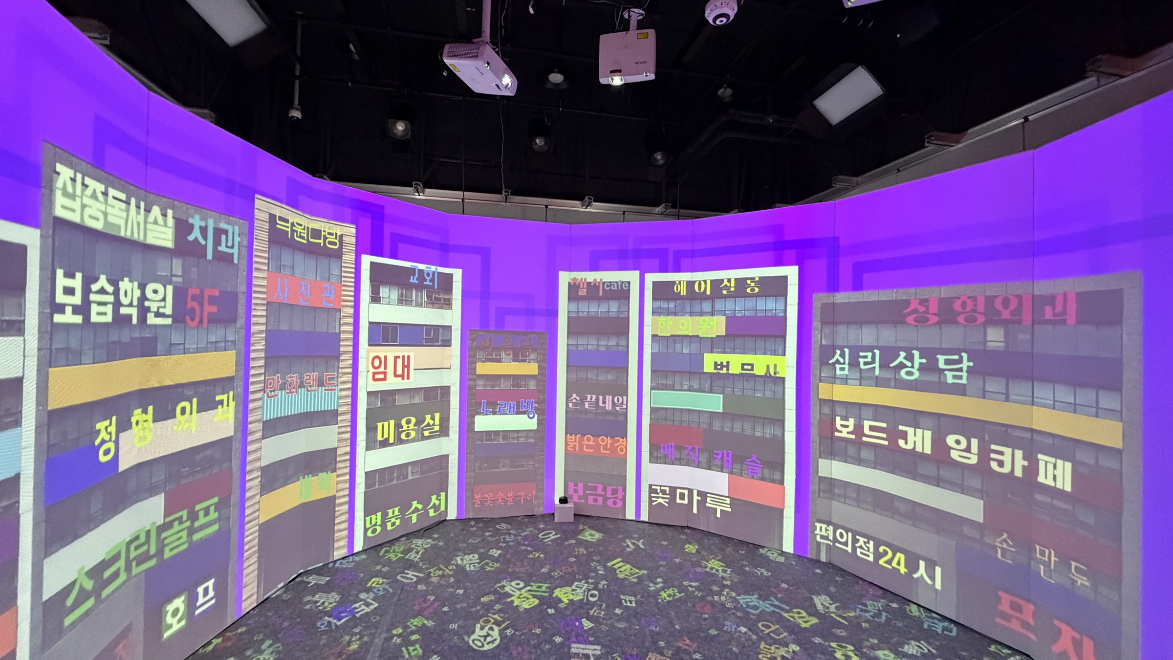 Installation view — sign scene. Four projectors across the 360° wall and floor